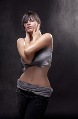 Naklejka premium Wet sexy young woman with a torn shirt. Fine spray of water.