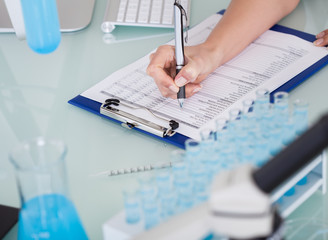 Female Scientist Writing On Notepad