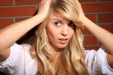 Blondine vor Ziegelwand