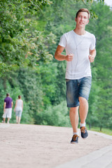 Fototapeta na wymiar young and handsome man running in park