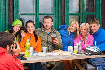 Man with camera taking photograph of friends