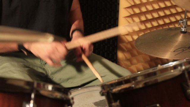 Drummer playing at drums set in a studio