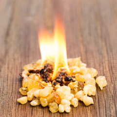 Brennender Weihrauch mit Flamme auf Holz