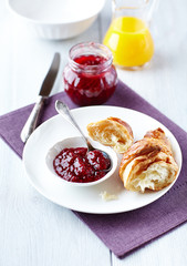 Croissant with raspberry marmalade on a plate