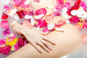 Obraz na płótnie Canvas Sexy young female in bath with flower petals.