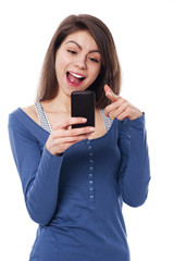 Excitement woman with mobile phone pointing at camera
