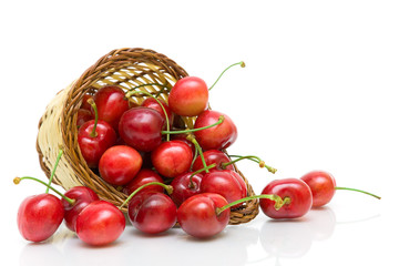 ripe cherry in a wicker basket on a white background close-up.