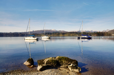 Fototapeta na wymiar Lake Windermere with three boats and a rock