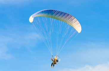 Paramotor on blue bright sky