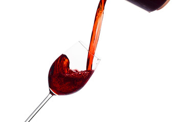 Rotwein wird in ein Weinglas eingegossen