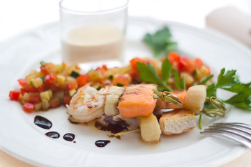 Closeup of grilled salmon and shrimps with vegetables.