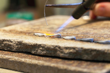 hands of jeweller at work silver soldering