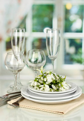 Serving dishes and snowdrops on room background