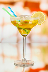 Yellow cocktail in glass on room background