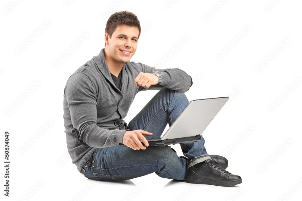 Poster Handsome guy working on a laptop and sitting on a floor