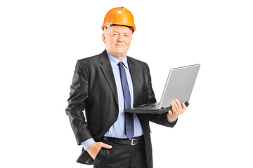 Experienced engineer posing with a laptop