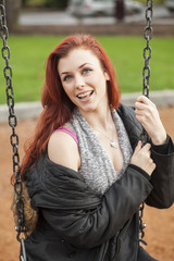 Young Woman with Beautiful Auburn Hair on a Swing