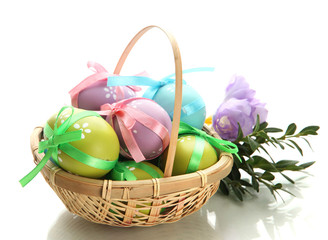 Bright easter eggs with bows in basket, isolated on white
