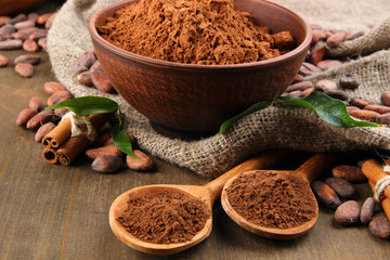 Cocoa powder and cocoa beans  on wooden background