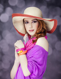 Beautiful red-haired girl in hat at bokeh background