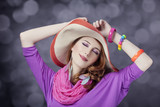 Beautiful red-haired girl in hat at bokeh background