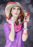 Beautiful red-haired girl in hat at bokeh background