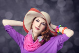Beautiful red-haired girl in hat at bokeh background