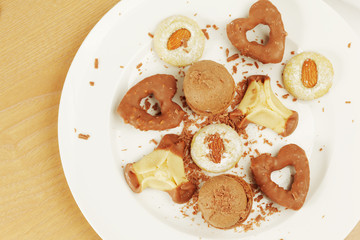 Several kinds of cookies and cakes on plate with crumbs