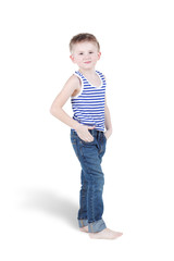 Smiling barefooted boy in striped singlet and jeans stands