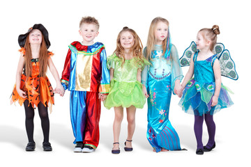 Smiling children dressed in carnival suits stand holding hands