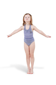 Little girl in striped swimsuit poses standing