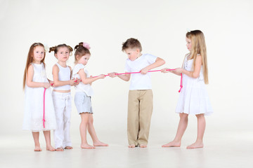 Obraz premium Five strained little children in white clothes draw over rope