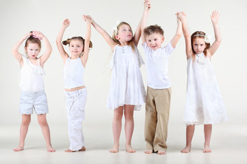 Naklejka premium Four cute little girls and one boy in white clothes