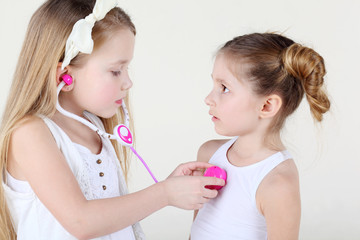 Little girl listens heartbeat of another frightened girl