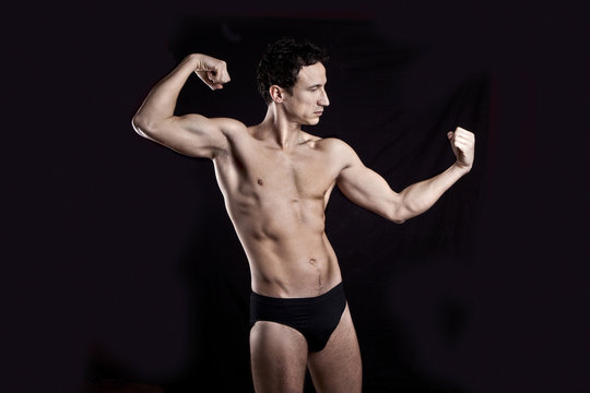 Handsome muscular guy  on black background