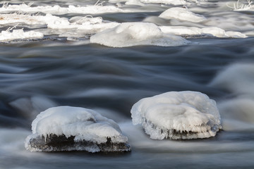 Eis an Felsbrocken im Flu&szlig;