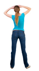 back view of standing young beautiful  blonde woman