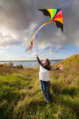Boy in autumn playing with kite