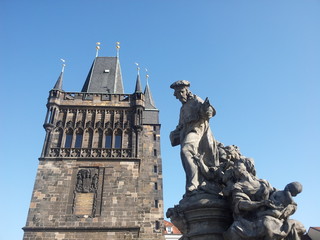 Statue on Charles bridge with tower in background