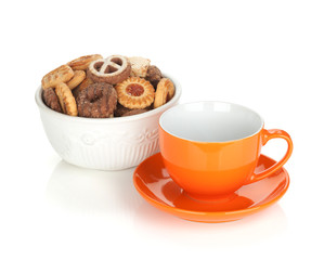 Various cookies in bowl and orange tea cup
