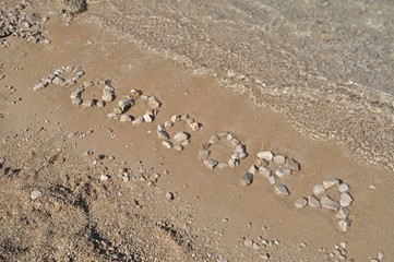 The Podgora word spelled out with pebbles on beach of Podgora