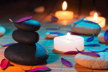 white and black stones, purple petals, and candles