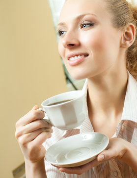 Young woman drinking coffee or tea, at home