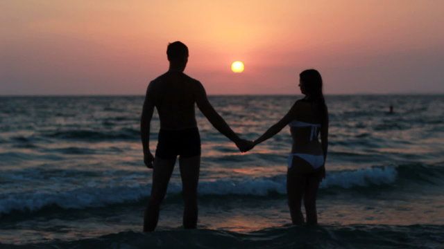 Couple silhouette at the beach. Sunset light.