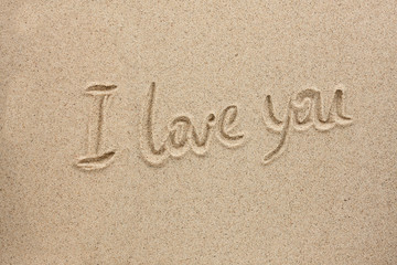 The word i love you written on the sand