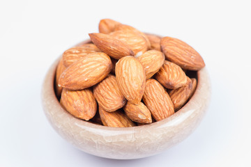 Almonds in bowl isolated on white background