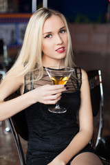 young women drinking a glass of alcoholic beverage at club