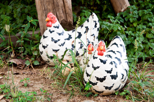 Chicken family cramic on the ground in the garden