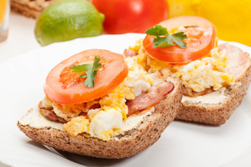 Sandwich with scrambled eggs and bacon. Selective focus.