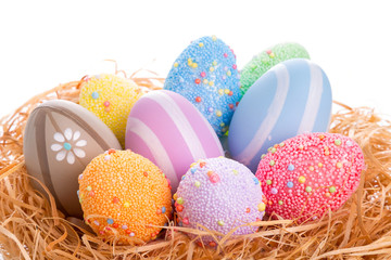 Colorful Easter eggs in the nest over white background